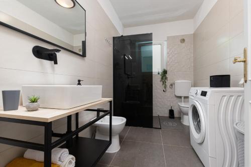 ein Badezimmer mit Waschbecken und Waschmaschine in der Unterkunft Cukerina apartment with Whirpool & Sauna in Poreč