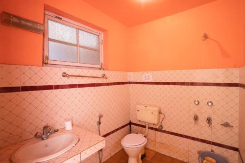 a bathroom with a toilet and a sink at Rainbow Hostelier in Leh