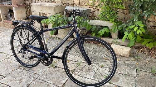 a black bike parked on a brick sidewalk at Karrua House - Magnolia Room in Modica