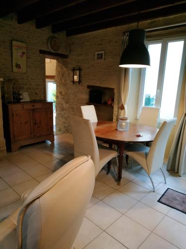 une salle à manger avec une table et des chaises dans l'établissement Maison de pêcheur, à Grandcamp-Maisy