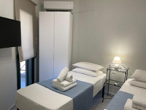 a room with two beds with towels and a tv at Nikiti, four seasons house in Nikiti