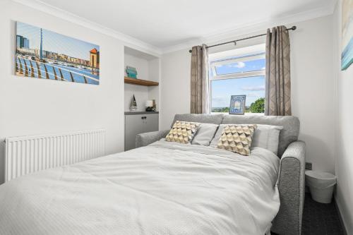 ein Schlafzimmer mit einem Bett und einem Fenster in der Unterkunft Cwtch on the Coast in Swansea