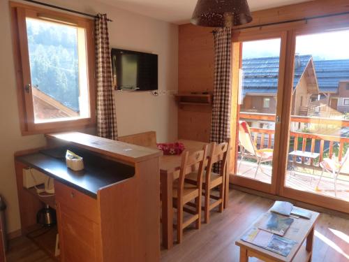 a kitchen with a table and a view of a balcony at residence avec piscine ,chalet des rennes in Vars