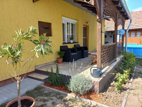 Casa amarilla con patio y sofá en Rózsa Vendégház en Abádszalók