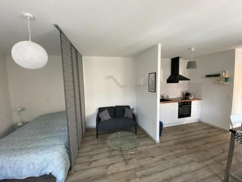 une chambre avec un lit et une table dans une pièce dans l'établissement Bel appartement avec micro ext et parking privé, à Clermont-Ferrand