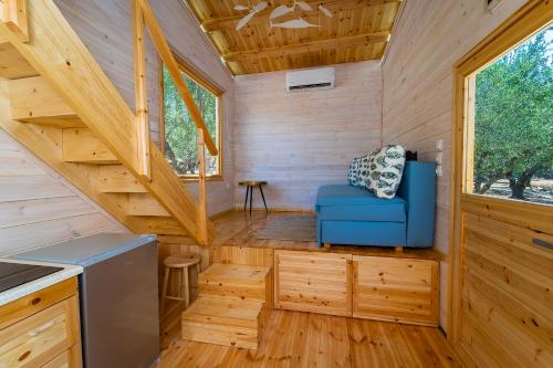 a tiny house with a blue couch in a kitchen at Thalassa Green in Agios Nikolaos