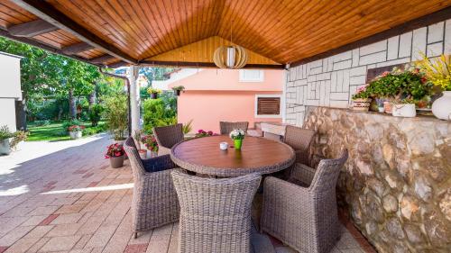 a wooden table and chairs on a patio at Rooms Nadica in Baška