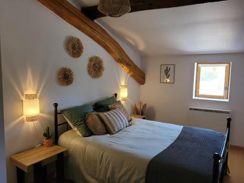 a bedroom with a bed with pillows and a window at Le cœur des Dombes in Bouligneux