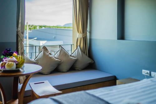 a room with a couch with pillows and a table at The Rubber Hotel Phuket in Thalang