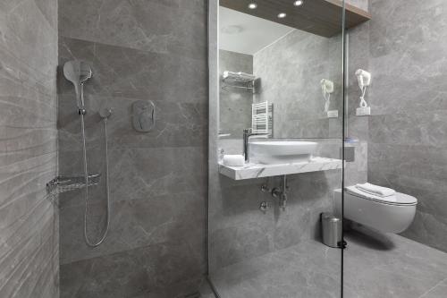 a bathroom with a shower and a sink and a toilet at Hotel Antonio in Makarska