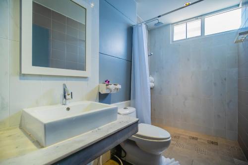 a bathroom with a white sink and a toilet at The Rubber Hotel Phuket in Thalang
