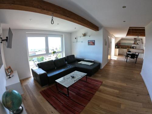a living room with a black couch and a table at Ferienwohnung Pauli in Mörbisch am See