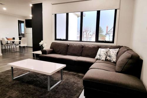 a living room with a couch and a table at Spacious Modern Apartment - St Kilda East in Melbourne