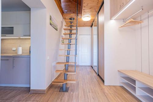 a spiral staircase in a kitchen with white walls and wooden floors at Schneider hause in Jūrmala
