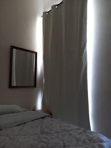 una camera da letto con un letto con specchio e tenda di AL CONVENTO a Scanno
