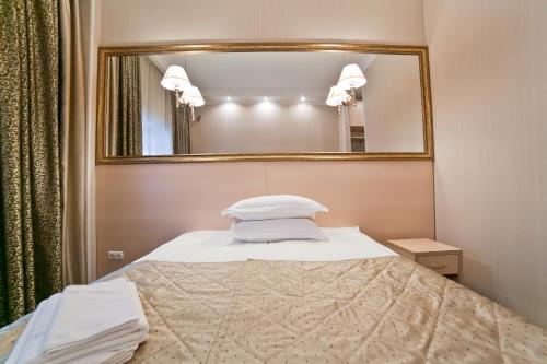 a bedroom with a bed with a mirror at Aruna Hotel in Astana