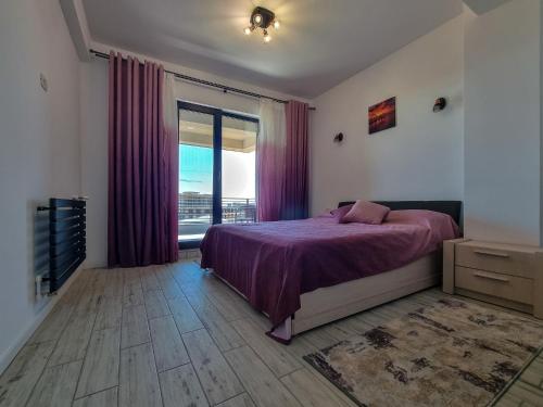 una camera con un letto e una grande finestra di MafMaf Apartments a Mamaia Nord - Năvodari