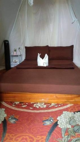a bed with two white towels on top of it at SHUKRAN Apartelle in Siquijor