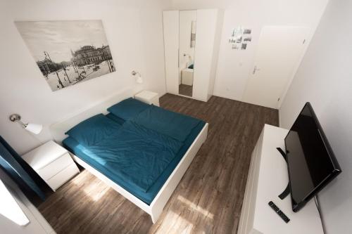 ライプツィヒにあるL.E. Homeのベッド1台とテレビが備わる小さな客室です。