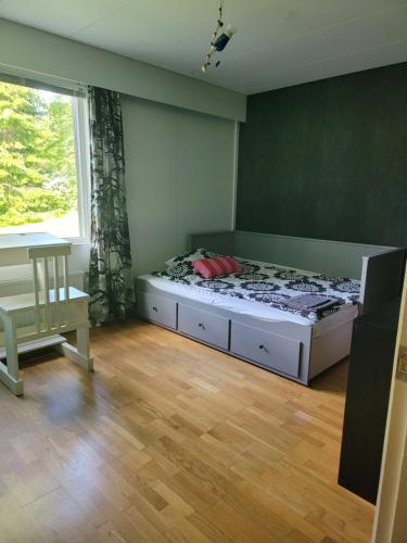 1 dormitorio con cama, mesa y ventana en Niittyvilla Apartments, en Jämsä
