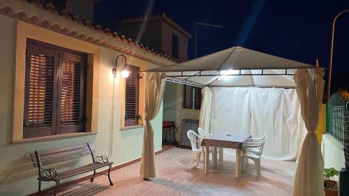 a table and chairs under an umbrella on a patio at La Gioia di Casa in Àrbatax