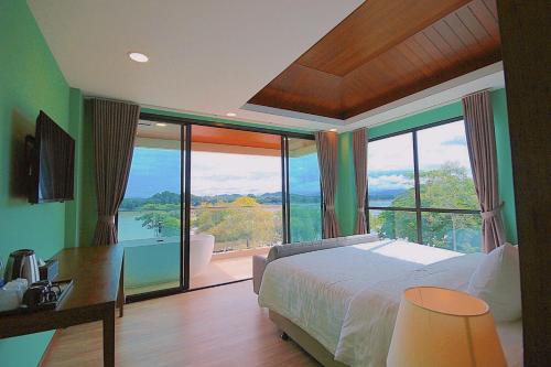 a bedroom with a bed and a large window at River Tree Resort in Chiang Khan