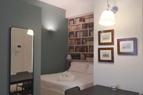 Schlafzimmer mit einem Bett, einem Schreibtisch und einem Spiegel in der Unterkunft OreaSpiti - Not Only a Suite in Magenta Quarter in Mailand