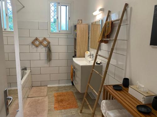 uma casa de banho com um lavatório e uma banheira em Ti kaz bo - Chambre vanille chez l'habitant em Bras-Panon