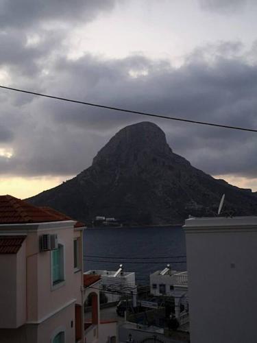 a mountain in front of the water with buildings at poets apertment in armeos masouri in Masouri