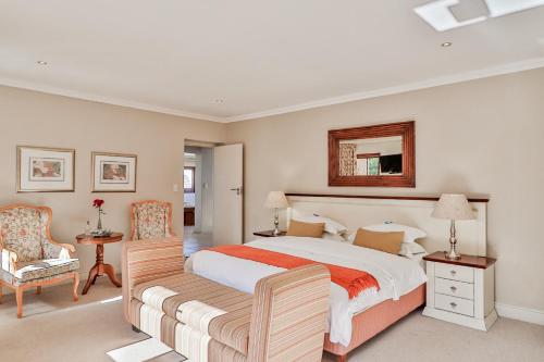 a bedroom with a large bed and a mirror at Lavender Manor Guest Lodge in Hermanus