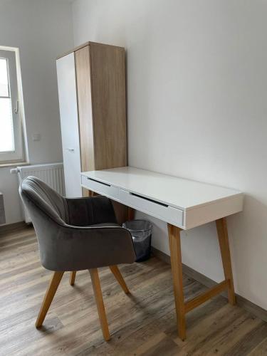 a desk with a chair and a white desk at Hotel Zur Post in Geest