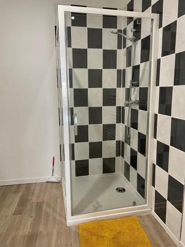 La salle de bains est pourvue d'une douche avec un mur en damier. dans l'établissement Au charme de Sarlat, à Sarlat-la-Canéda