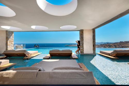 a room with a pool with beds and a view at Tropicana Hotel , Suites & Villas Mykonos in Paradise Beach