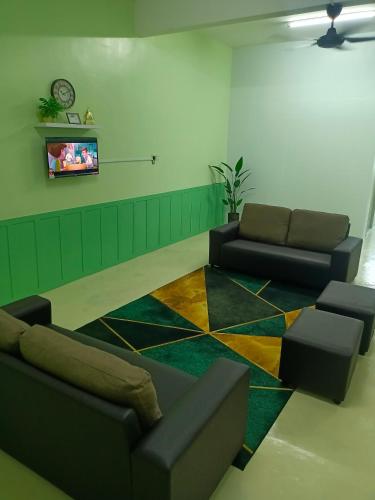 a living room with two couches and a tv at Homestay Muslim in Kuala Ketil