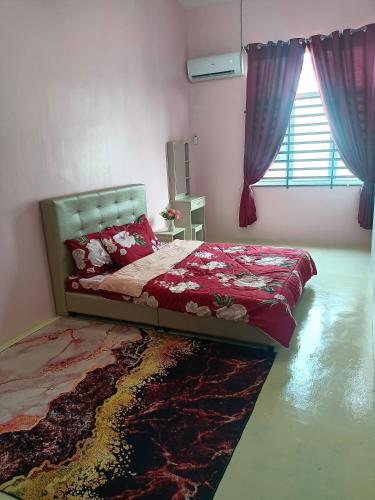 a bedroom with a bed with red sheets and a window at Homestay Muslim in Kuala Ketil