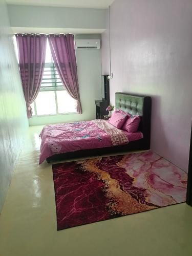 a bedroom with a bed with pink sheets and a window at Homestay Muslim in Kuala Ketil