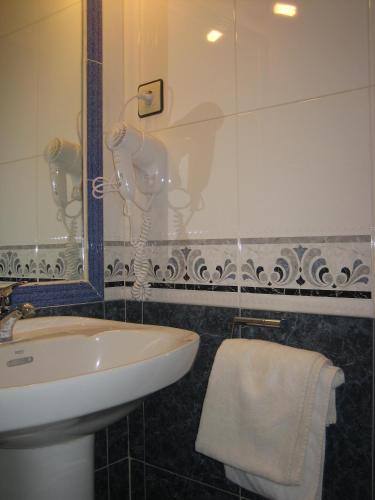 a bathroom with a sink and a mirror at Hostal Restaurante la Trucha in Benavente