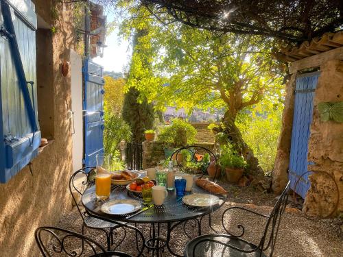 Una mesa con comida y bebidas en un patio. en Le jardin de Camille, en Cotignac
