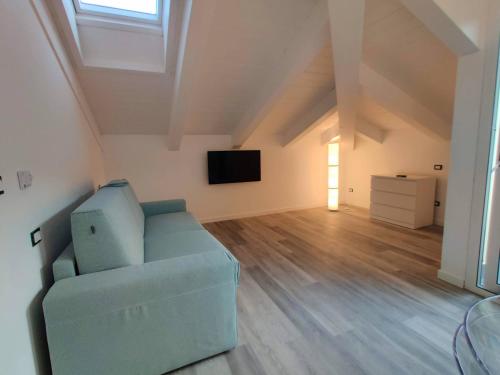 a living room with a blue couch and a television at Sotto il Cielo in Finale Ligure