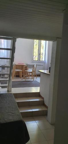 a bedroom with stairs leading to a dining room with a table at La roussette in Collioure