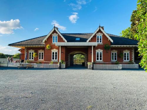 a large red brick house with an archway at Stoke Edith Station in Hereford