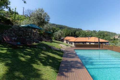 una piscina in un cortile con una casa di ALDEIA DA MARGARIDA a Tarouquela