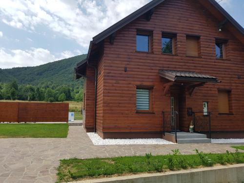 a wooden house with a hill in the background at Villa Kum in Tuk Vojni