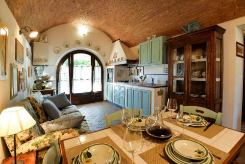 a kitchen and living room with a table and a couch at Appartamento Vecchio Mulino in Isola d'Arbia