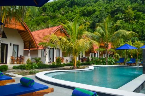 a villa with a swimming pool and a resort at Penida Bay Village in Nusa Penida