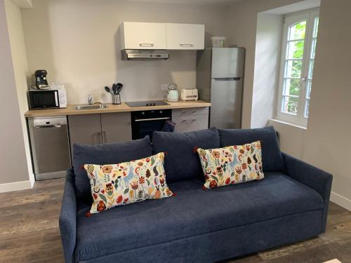 - un canapé bleu avec deux oreillers dans la cuisine dans l'établissement Les Appartements - Les Anges Béarnais I et Les Anges Béarnais II, à Sauveterre