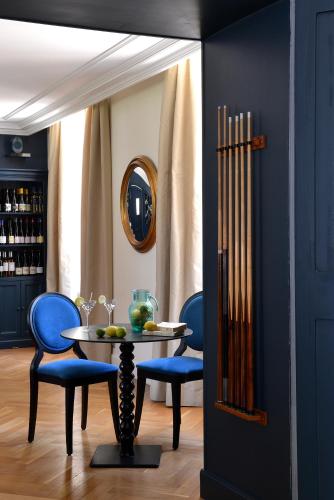 a dining room with a table and blue chairs at Château Saint Gilles - Bayeux in Guéron