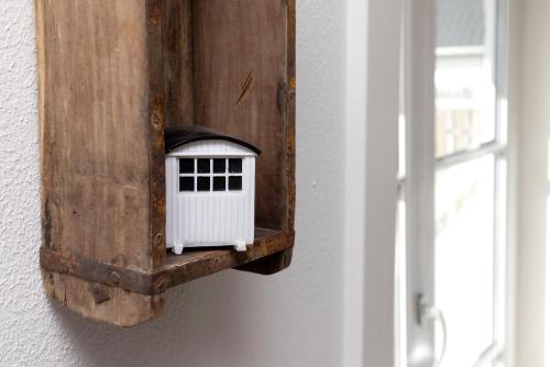a bird house on a wall next to a window at Havrevang, Ferielejligheder in Lønstrup