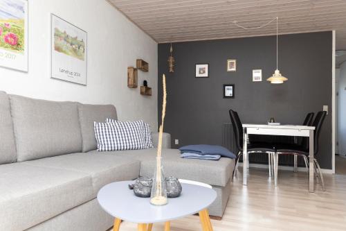 a living room with a couch and a table and a piano at Havrevang, Ferielejligheder in Lønstrup