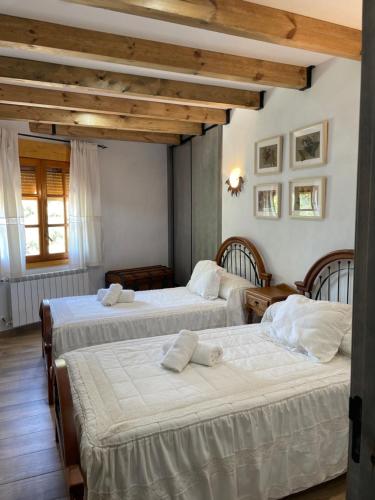 - 2 lits dans une chambre dotée de plafonds en bois dans l'établissement Vivienda Turistica Alojamiento Rural CASA IRENE II, à Segura de la Sierra